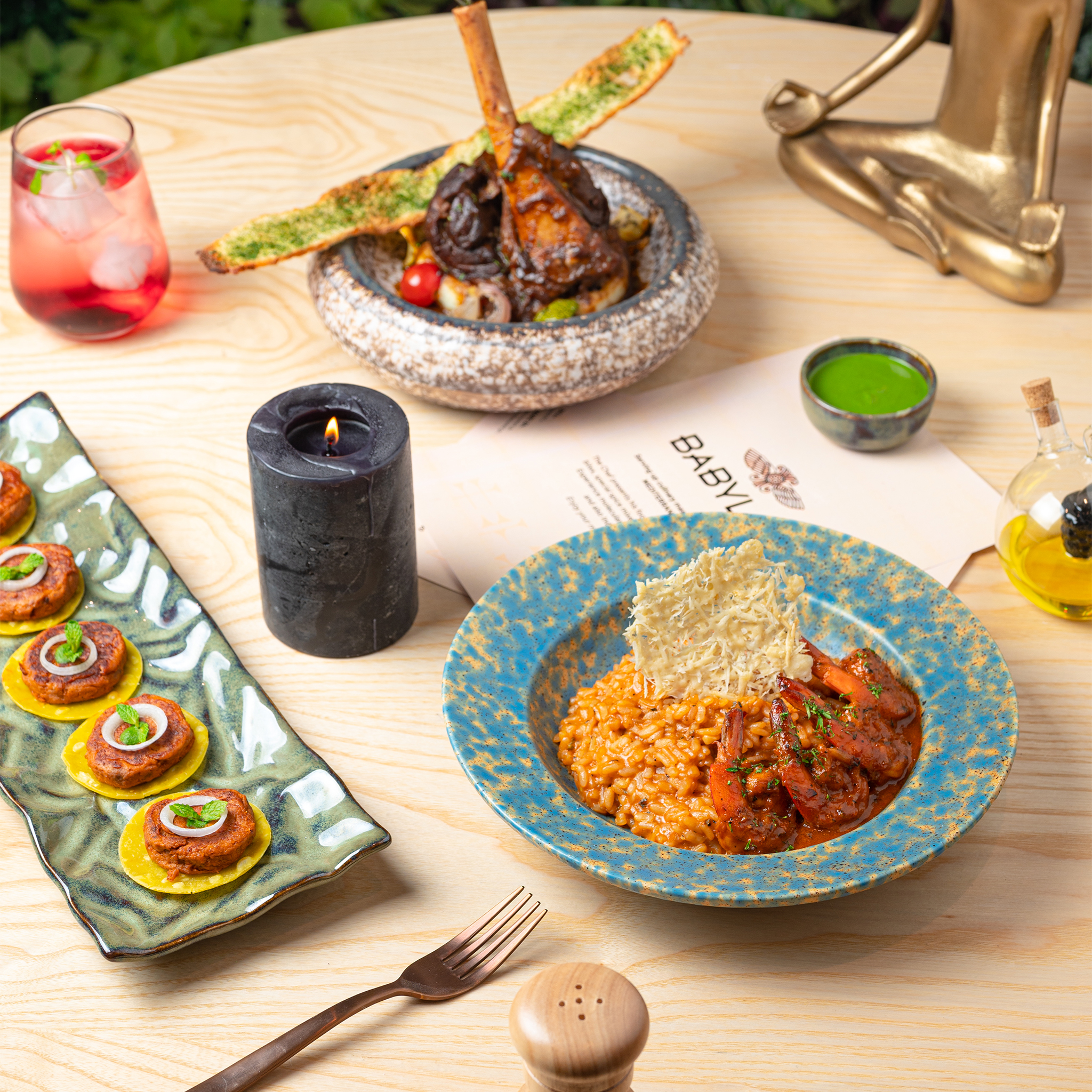 Plated dishes, a Babylon menu and tableware on a restaurant table