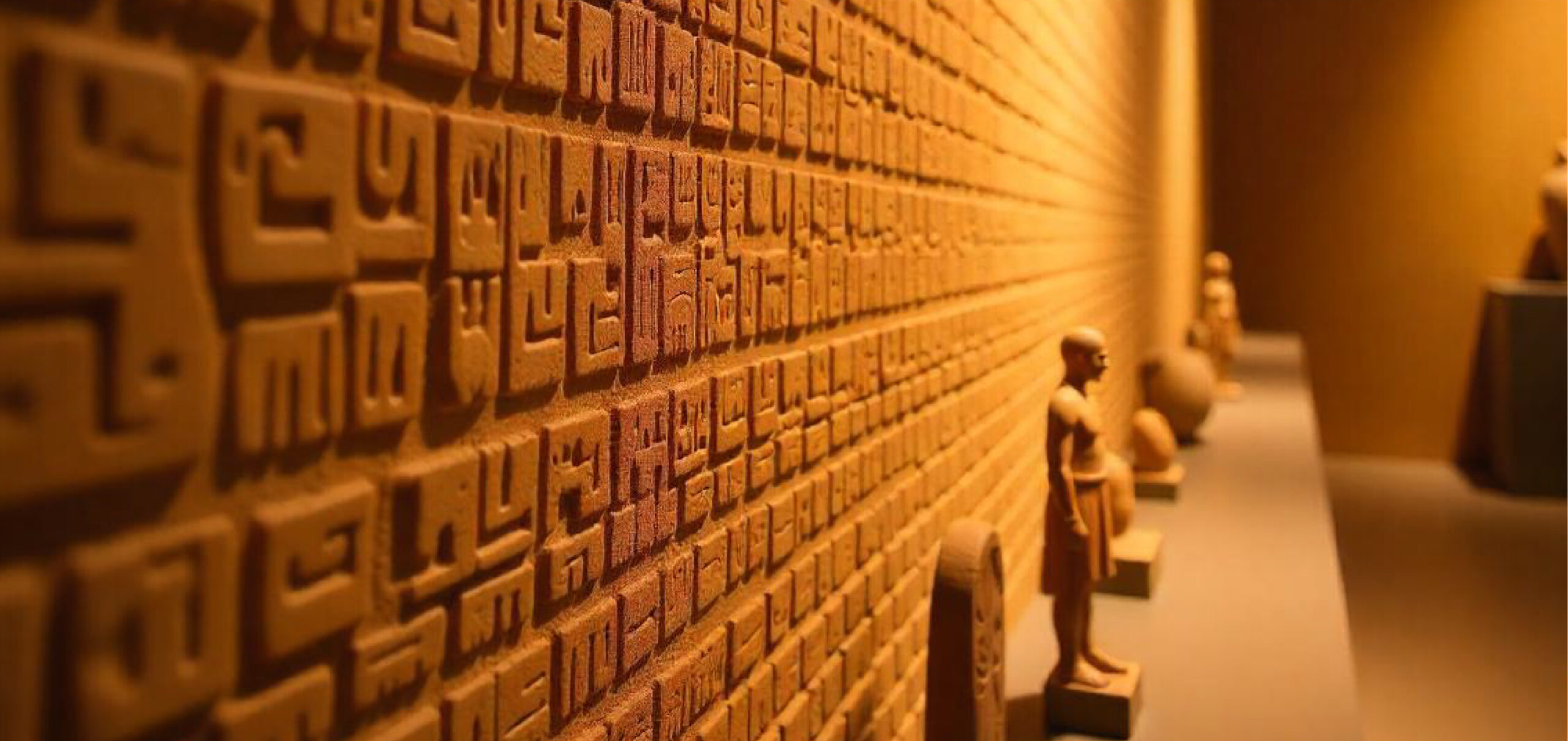 Carved Babylonian symbols on a warmly lit restaurant wall